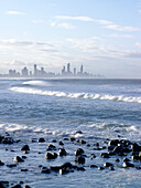 Blick über die Wellen und das Meer auf die Stadt und die Küste von Surfers Paradise