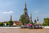 Ausflugsboot und Steg am Fluss Chao Phraya neben dem buddhistischen Tempel Wat Arun