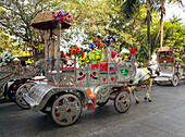 Reihe von dekorierten Pferdekutschen aus Metall in der belebten Straße von Mumbai