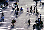 Luftaufnahme von Menschen, die eine Kreuzung auf der Straße überqueren, die alle in verschiedene Richtungen gehen
