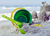 Bucket and spade in the sand next to sandcastles