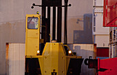 Close up of forklift working with shipping containers on the port