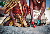 Zwei gebürtige Fidschi-Männer in traditioneller Kleidung schlagen Holzstöcke und machen Musik