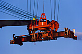 Man operating crane to load and unload shipping containers at the port
