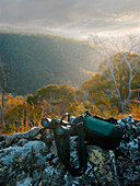 Binoculars and drinking bottle on rock in Australain bushland