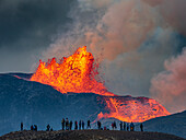 Hikers enjoy fireworks from Observation Hill as glowing lava is ejected from Fagradalsfjall Volcano, Iceland