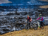Mountainbiker, einheimische Isländer, die Lavaströme vom Vulkan Fagradalsfjall, Island, besuchen