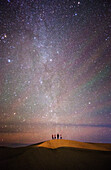 Starlit night with friends on a sand dune