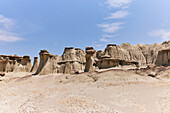 Sandstone hoodoos and a clear blue sky at Ah-shi-sle-pah Wilderness Study Area in New Mexico. Area is located in northwestern New Mexico and is a badland area of rolling water-carved clay hills. It is a landscape of sandstone cap rocks and scenic olive-colored hills. Water in this area is scarce and there are no trails; however, the area is scenic and contains soft colors rarely seen elsewhere