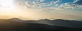 Sonnen, die am späten Nachmittag auf Schichten von Hügeln scheinen, aufgenommen vom O'Reilly's Plateau mit Blick auf The Dividing Range