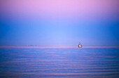 Boat on tropical ocean at sunset