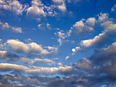 Wolken und Mond im blauen Himmel
