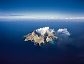 Luftaufnahme des aktiven Vulkans Whiste Island, der inmitten des blauen Ozeans raucht