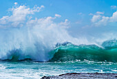 Riesige Welle, die sich während des Zyklons Ola kräuselt und bricht