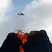 Halbinsel Reykjanes, Island - 23. März 2021: Vulkanausbruch Halbinsel Reykjanes Island, mit einem Flugzeug im Hintergrund. Vulkan Fagradalsfjall, Geldingadalir-Ausbruch