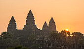 Die Sonne geht neben dem Tempel von Angkor Wat auf.
