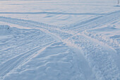Abstrakte Aufnahme von Spuren im Schnee bei Sonnenaufgang. Winterszene in Schwedisch Lappland