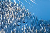 Luftaufnahme von zwei eingeschneiten Hütten nach einem Schneesturm im finnischen Lappland