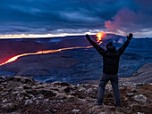 Feier, Wanderer sieht glühenden Fluss aus Magma und den Vulkanausbruch des Fagradalsfjall in Geldingadalir, Island