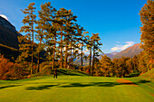 Golfer Putting Green auf dem Golfplatz Menaggio mit Blick auf die Berge im Herbst in der Lombardei, Italien