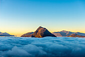 Berggipfel San Salvatore über Wolkengebilde mit Sonnenlicht und klarem Himmel in Lugano, Tessin in der Schweiz