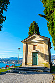 Kirche mit Stadtbild und Zypresse mit klarem blauem Himmel im Park San Michele in Castagnola in Lugano, Tessin in der Schweiz