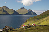 Blick auf Dorf und Kirche Kunoy, Färöer. Berge und Fjord.