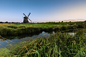 Schöpfmühle Neustadt-Gödens, Friesland, Germany. Windmill on a meadow with a moat.