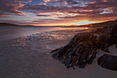Sonnenuntergang am Strand. Felsne im Vordergrund. Losgaintir, Harris, Schottland, Vereinigtes Königreich.