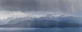 Panorama Blick auf Inseln Skorpa und Spildra im Regen, Sorstraumen, Troms, Norwegen. Schnee auf Gipfel