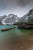 Hütte auf Pfählen mit Ruderbooten im Bergsee Pragser Wildsee, Braies, Südtirol, Italien.