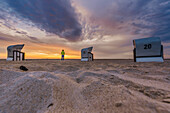 Touristin am Strand blickt aufs Meer, Strandkörbe im Sonnenuntergang, Ostsee, Nationalpark Vorpommersche Boddenlandschaft, Fischland-Darß-Zingst, Mecklenburg-Vorpommern, Deutschland