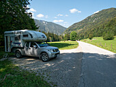 Motorhome is at the road wheel in the mountains.