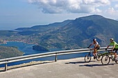 Cyclists on a quiet Ithaca island road, here overlooking Vathy Bay, Ithaca, Ionian Islands, Greece