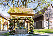 Easter fountain decorated with colorful Easter eggs in Wohlmuthshüll in Franconian Switzerland, Bavaria, Germany