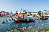 Barcos Rabelos, port wine boats on the Duero River in front of the Dom Luís I Bridge and the historic old town of Porto, Portugal