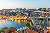 Dom Luís I half-timbered arch bridge over Douro river and historic old town at night in Porto, Portugal