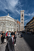 People in front of the baptistery and facade of the Duomo, Cathedral of Santa Maria del Fiore, Florence, Tuscany, Italy