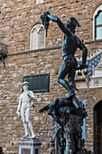 Skulptur Perseus mit dem Haupt der Medusa von Benvenuto Cellini, Loggia dei Lanzi, Piazza della Signoria, Davidstatue im Hintergrund, Florenz, Toskana, Italien, Europa