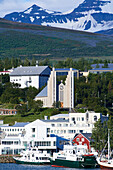 View across the harbor to the imposing Akureyrarkirkja Evangelical Lutheran Church on a hill, with many stained glass windows and a large organ.