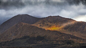 Single ray of sun hits mountains on Kerry Peninsula. Cummers East, Ardea, County Kerry, Ireland.