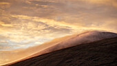 Clouds gather over Mount Cruach Mhartain at sunrise. Golden light. Clogher, Dnurlin, County Kerry, Ireland.