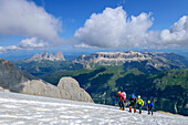 Four people mountaineering climb over snow to the top of Marmolada, Marmolada, Dolomites, Dolomites UNESCO World Heritage Site, Trentino, Italy
