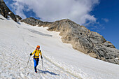 Woman mountaineering descends over glacier from Marmolada, Marmolada, Dolomites, Dolomites UNESCO World Heritage Site, Trentino, Italy