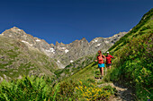 Mann und Frau beim Wandern steigen zum Refuge Vallonpierre auf, Valgaudemar, Nationalpark Ecrins, Dauphine, Provence-Hautes Alpes, Frankreich