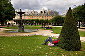 Mann mit dem Rücken zum Formschnitt und Brunnen, Place des Vosges, Marais, Paris, Frankreich