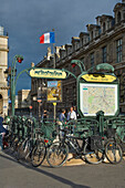 Art-Deco-U-Bahn-Eingang durch den Louvre, Paris, Frankreich mit Fahrrädern, französische Flagge