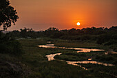 A landscape of a winding river at sunset