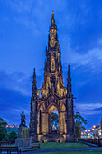 Scott Monument gothic constrution lit up at dusk, Edinburgh, UK