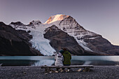 Couple in front of Mount Robson above Berg lake at dawn, Canada